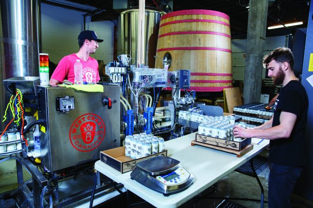 Loading cardboard flats with filled cans. PHOTO: Roger Mahler